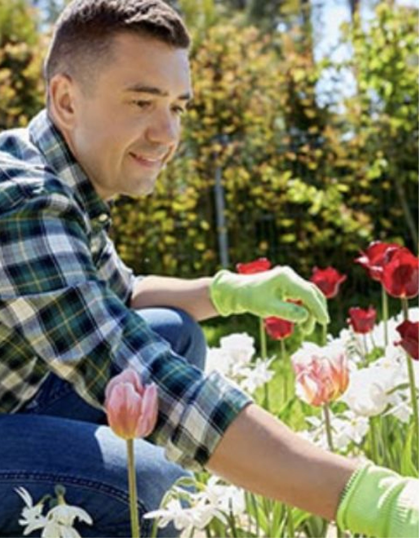 Un uomo con camicia a scacchi è accovacciato in un prato di fiori